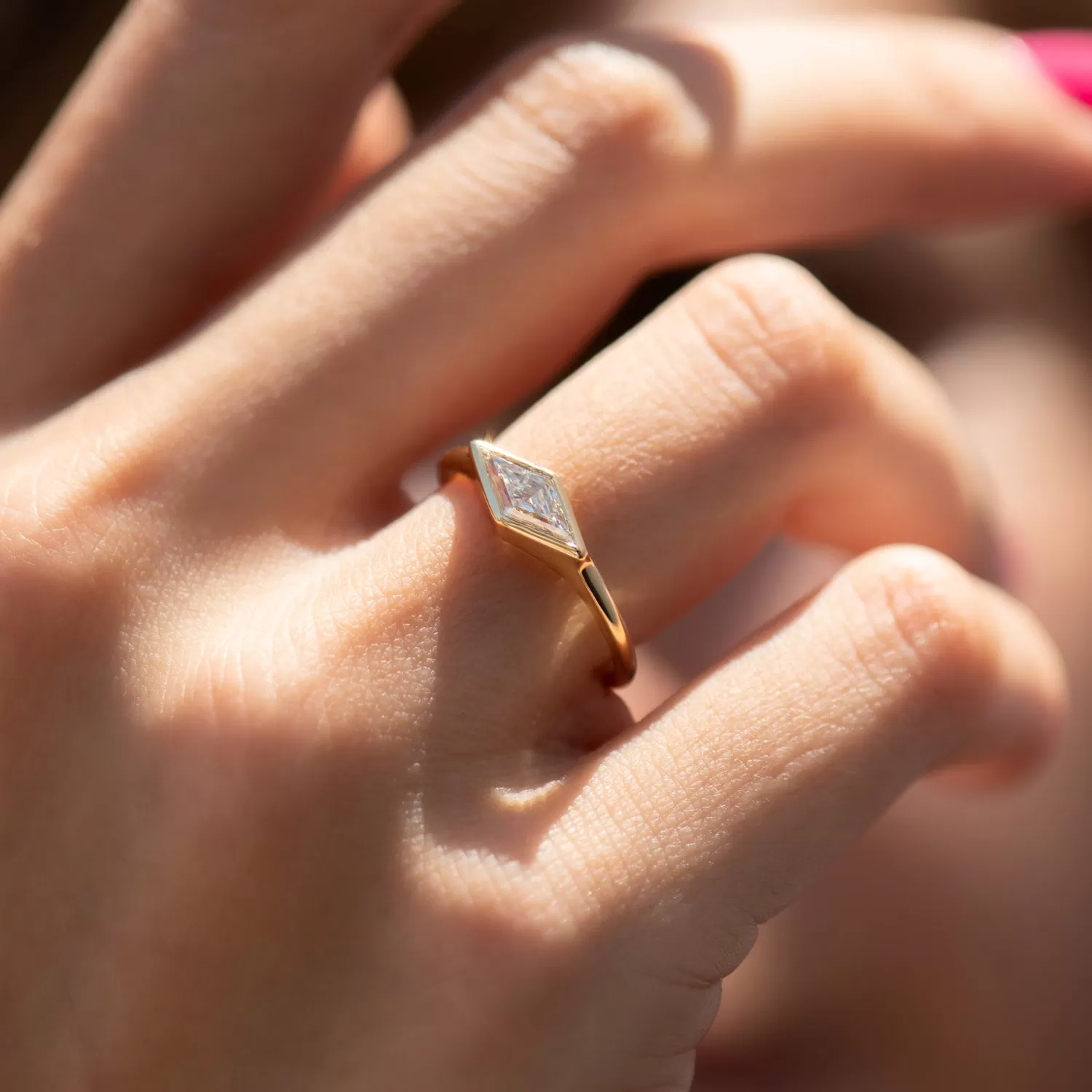 Lozenge Cut Diamond Engagement Ring with a Golden Bezel